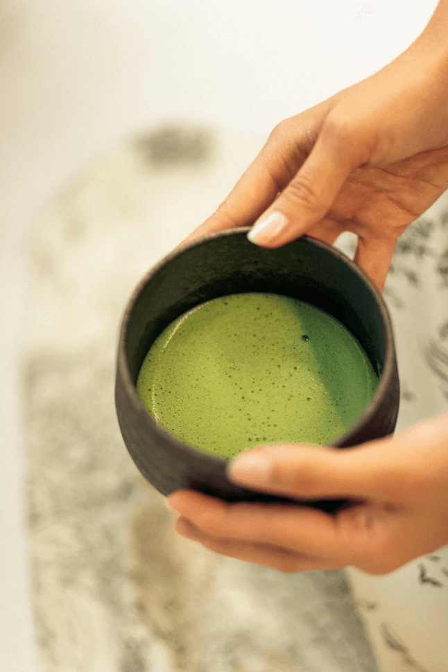 Mâini care țin un bol cu matcha